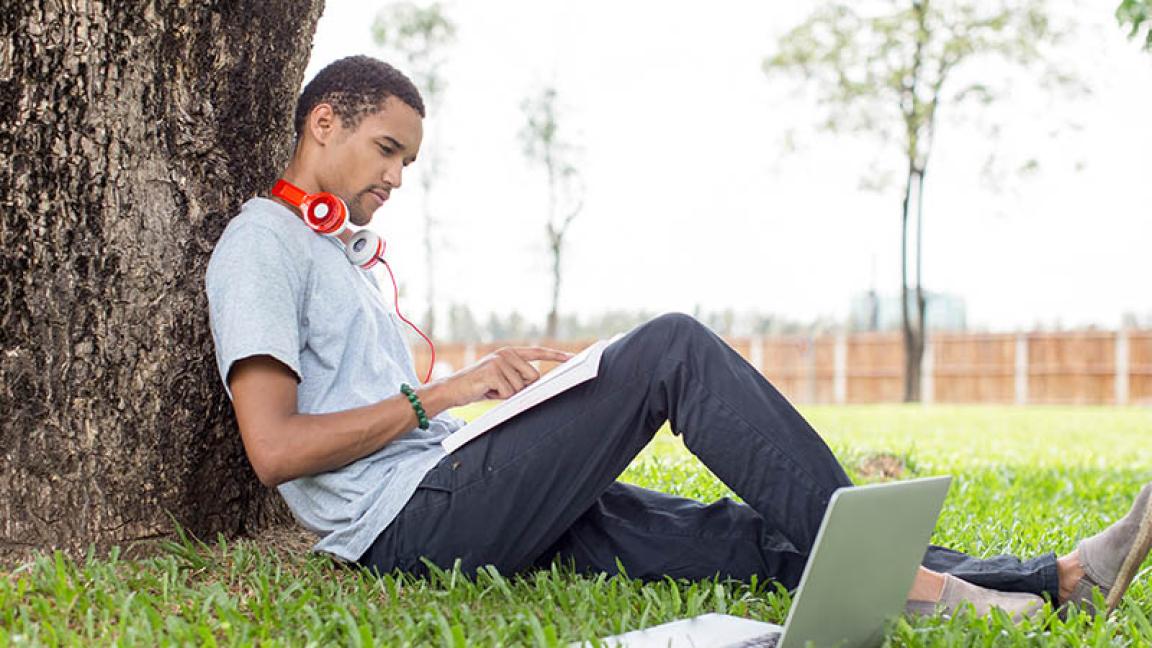student studying by tree
